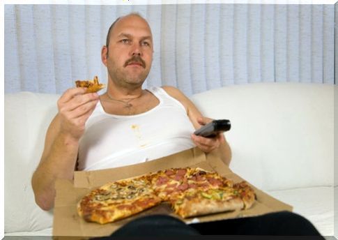 Mr on the couch watching TV while eating a pizza