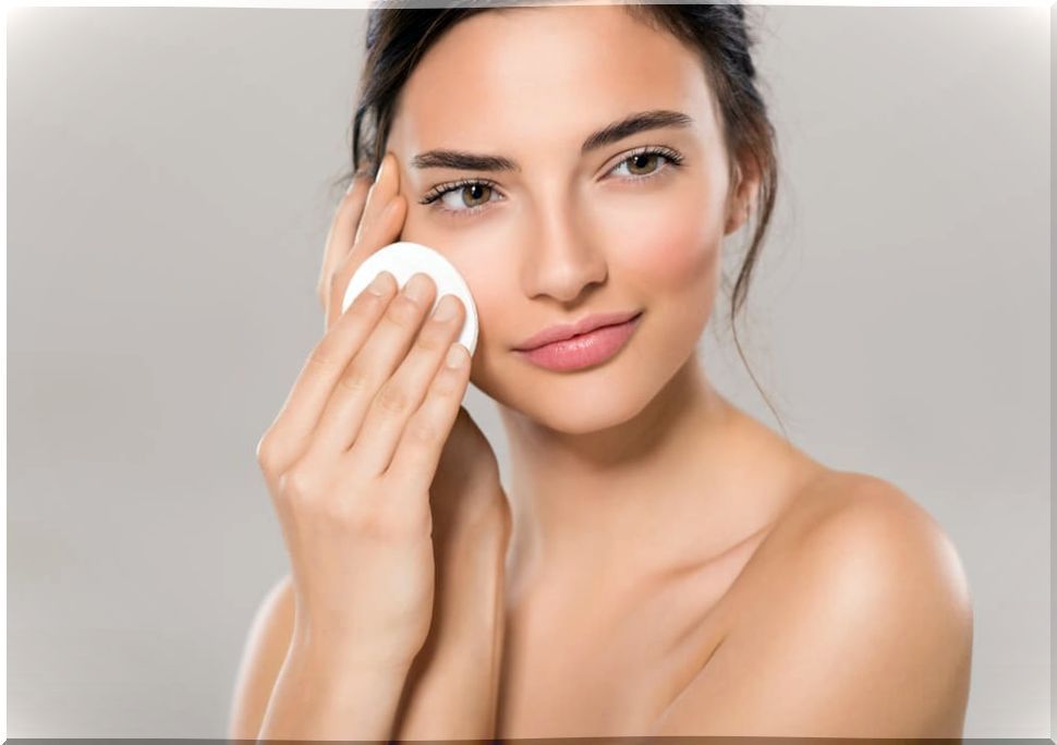 Woman applying a cotton pad to her face