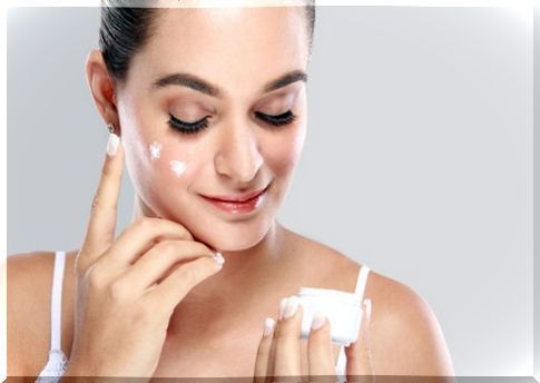 Woman applying a cream to her face.