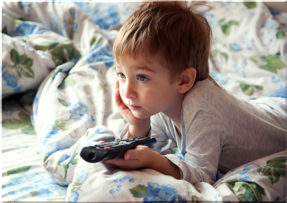 Child in bed watching television.